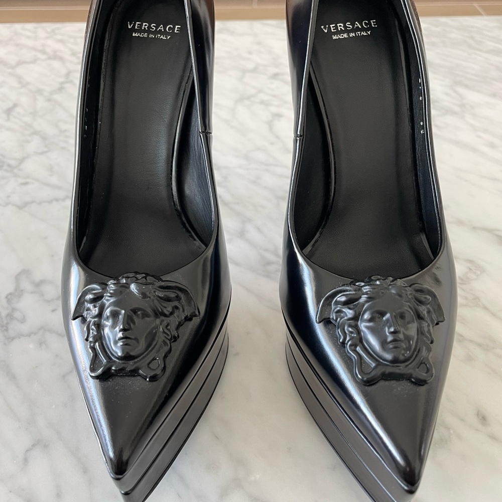 Versace platform point toe stiletto heels. Black leather with Medusa accent.